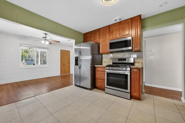 an empty room with a window and a ceiling fan
