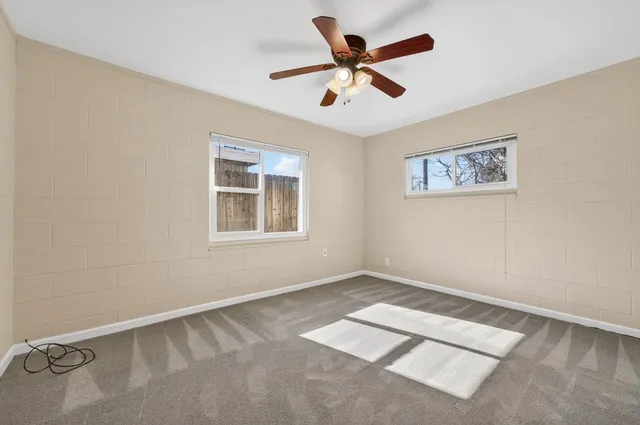 an empty room with closet and a chandelier fan