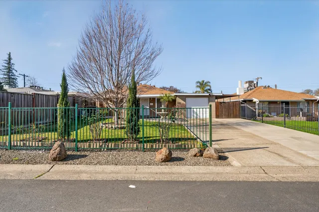 an empty room with wooden floor fireplace and large window