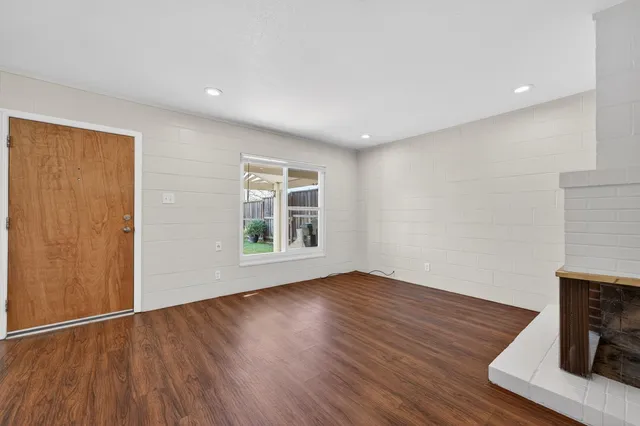 a view of a room with wooden floor and a chandelier fan