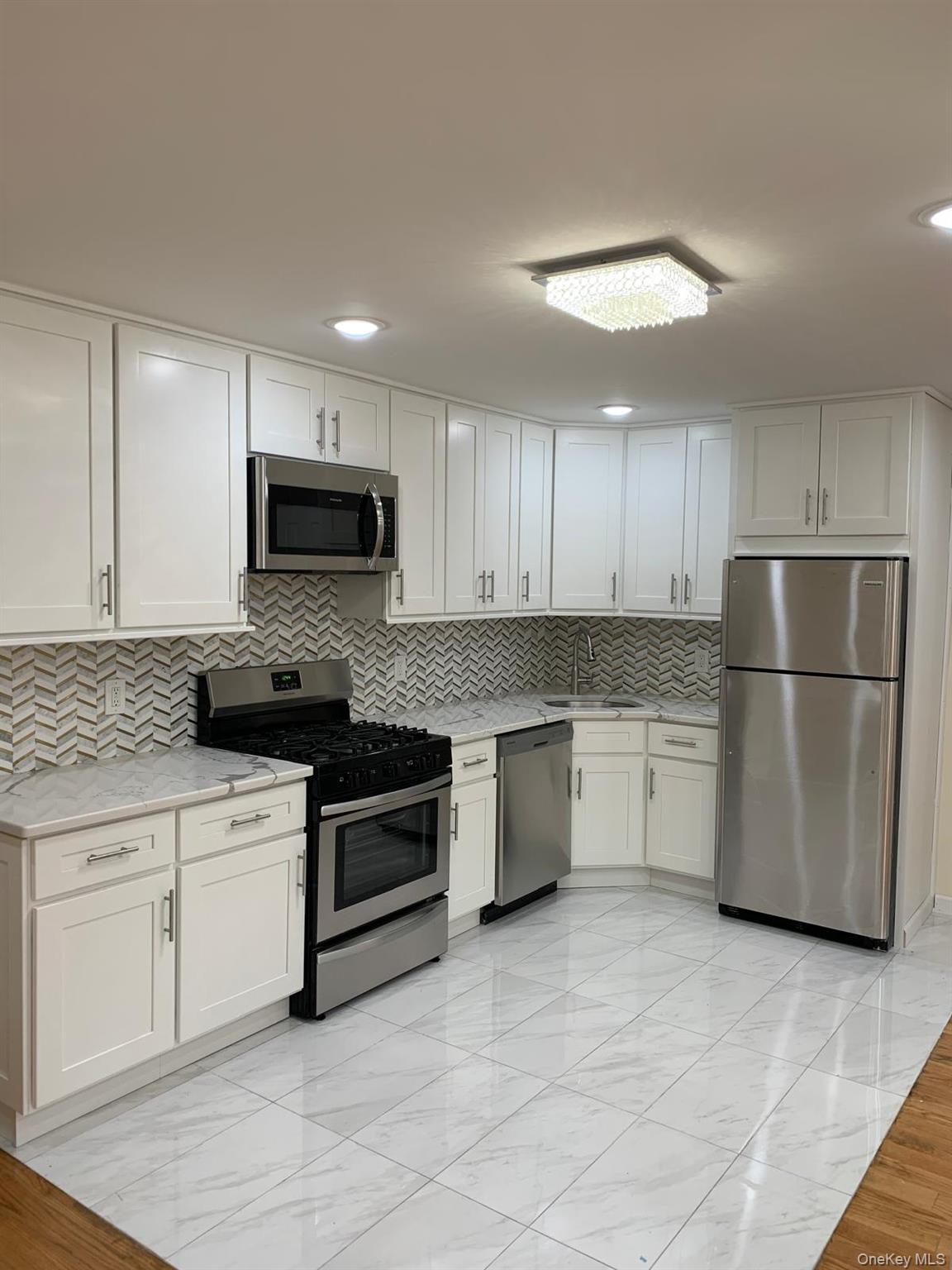 39 Ann Street Ossining, NY 10562 - Photo 3 of 27 a kitchen with a refrigerator a microwave a sink and cabinets