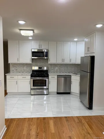 a kitchen with granite countertop a refrigerator and a stove top oven