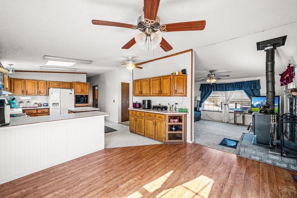 8435 Savage Road Beulah, CO 81023 - Photo 4 of 34 a kitchen with stainless steel appliances wooden floor and a refrigerator