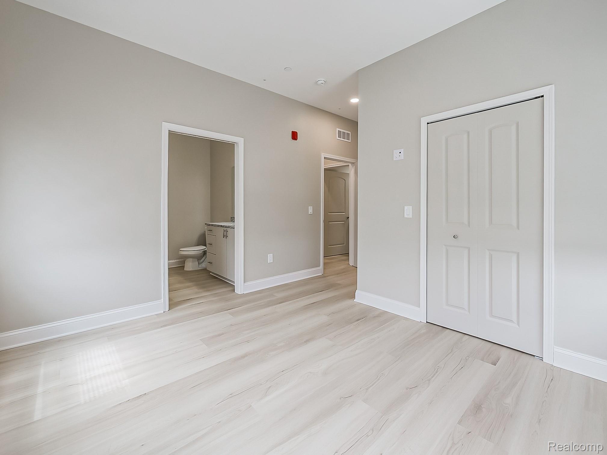 31480 Warren Road, Unit 101 Westland, MI 48185 - Photo 16 of 26 Unfurnished bedroom with light wood-type flooring, a closet, and ensuite bathroom