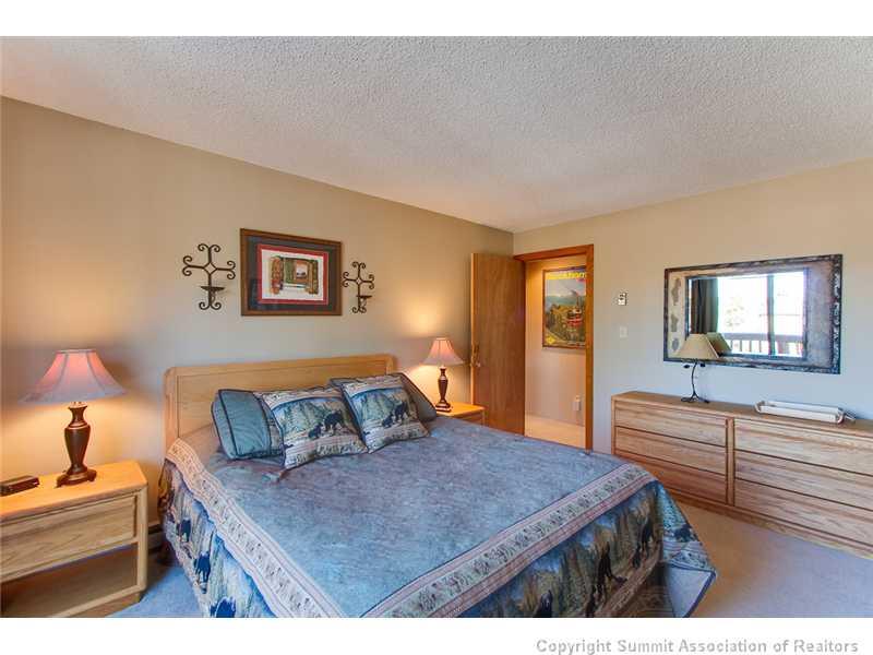350 4 O Clock Road, Unit D Breckenridge, CO 80424 - Photo 4 of 5 a bedroom with a bed and a chandelier