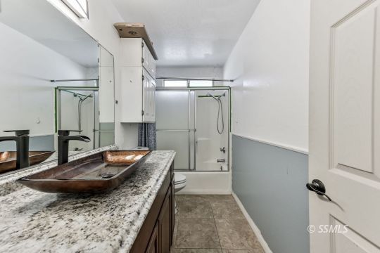 301 South Lincoln Street Ridgecrest, CA 93555 - Photo 12 of 20 a bathroom with a granite countertop sink a mirror and shower