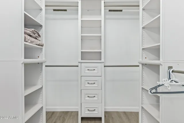 a view of walk in closet with empty racks