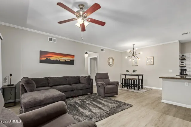 a living room with furniture a dining table and paintings on the wall
