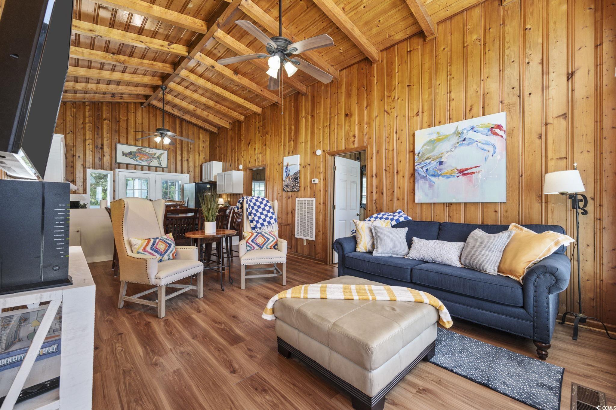 Living room with high vaulted ceiling, wooden ceiling, and wood-type flooring
