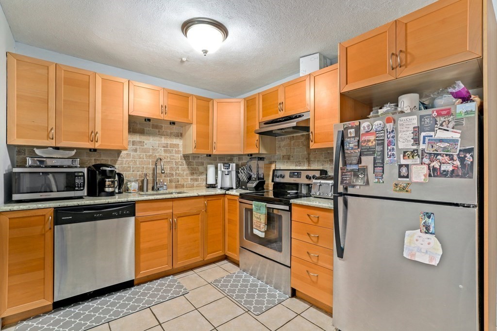 47 West Street, Unit C4 Randolph, MA 02368 - Photo 7 of 19 a kitchen with stainless steel appliances granite countertop a stove a sink and a microwave