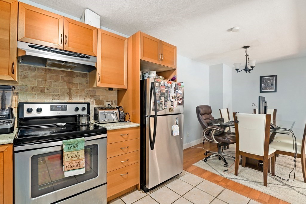 47 West Street, Unit C4 Randolph, MA 02368 - Photo 8 of 19 a kitchen with stainless steel appliances granite countertop a stove a refrigerator and white cabinets with wooden floors