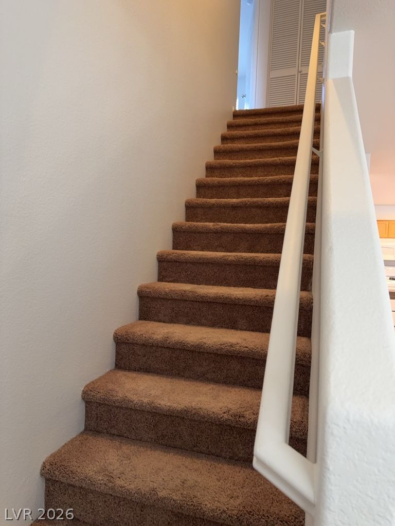 4790 Pinon Pointe Road Las Vegas, NV 89115 - Photo 8 of 16 Carpeted staircase with a crisp white railing invites you to the upper level.