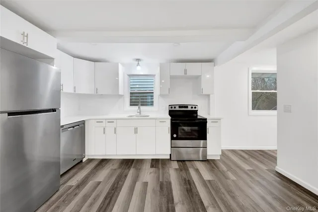 a kitchen with a refrigerator stove and white cabinets