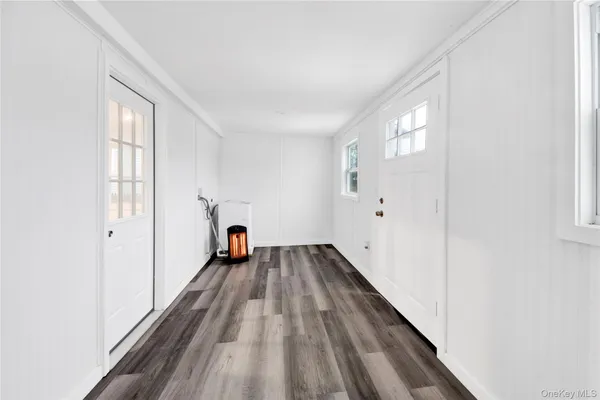 a view of a room with wooden floor staircase and a hallway