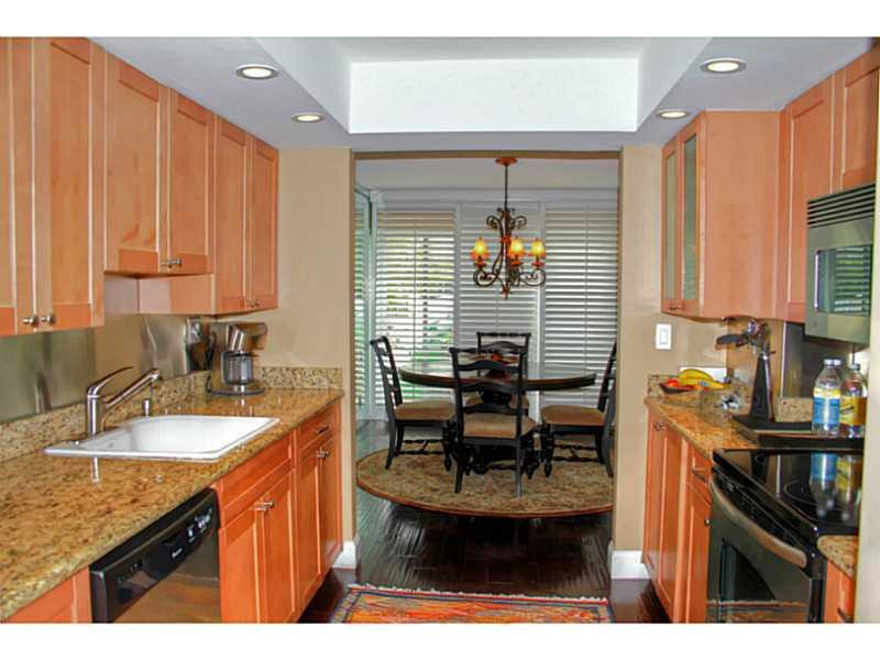 125 North Birch Road, Unit 107 Fort Lauderdale, FL 33304 - Photo 12 of 35 a kitchen with sink refrigerator and cabinets