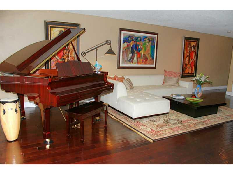 125 North Birch Road, Unit 107 Fort Lauderdale, FL 33304 - Photo 6 of 35 a living room with furniture and wooden floor