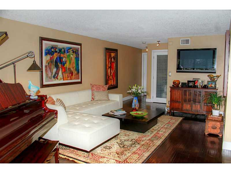 125 North Birch Road, Unit 107 Fort Lauderdale, FL 33304 - Photo 8 of 35 a living room with furniture and a flat screen tv