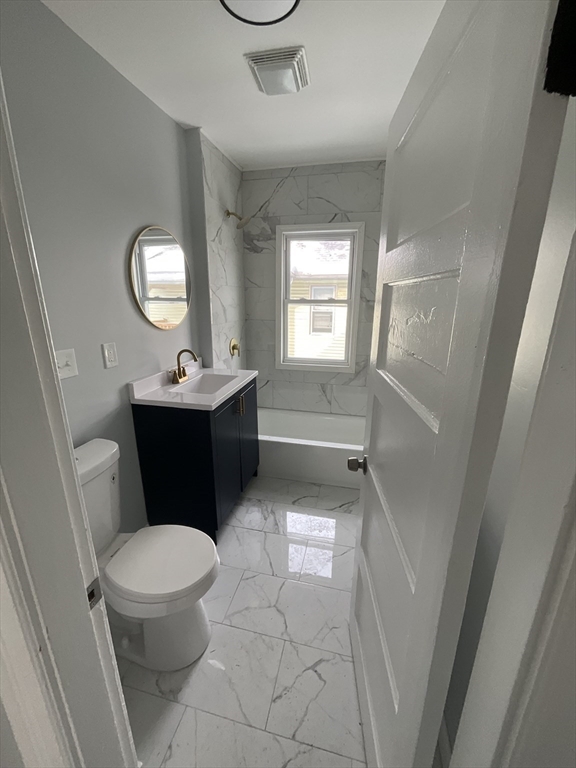 25 Malden Street, Unit 2 Springfield, MA 01108 - Photo 2 of 10 a bathroom with a toilet a sink a window and a mirror