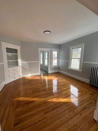 a view of empty room with window and wooden floor