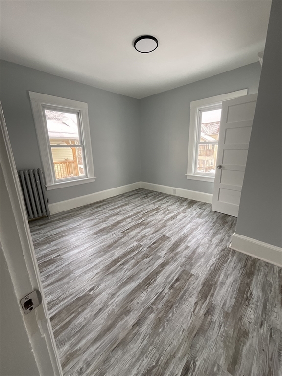 25 Malden Street, Unit 2 Springfield, MA 01108 - Photo 7 of 10 an empty room with wooden floor and windows
