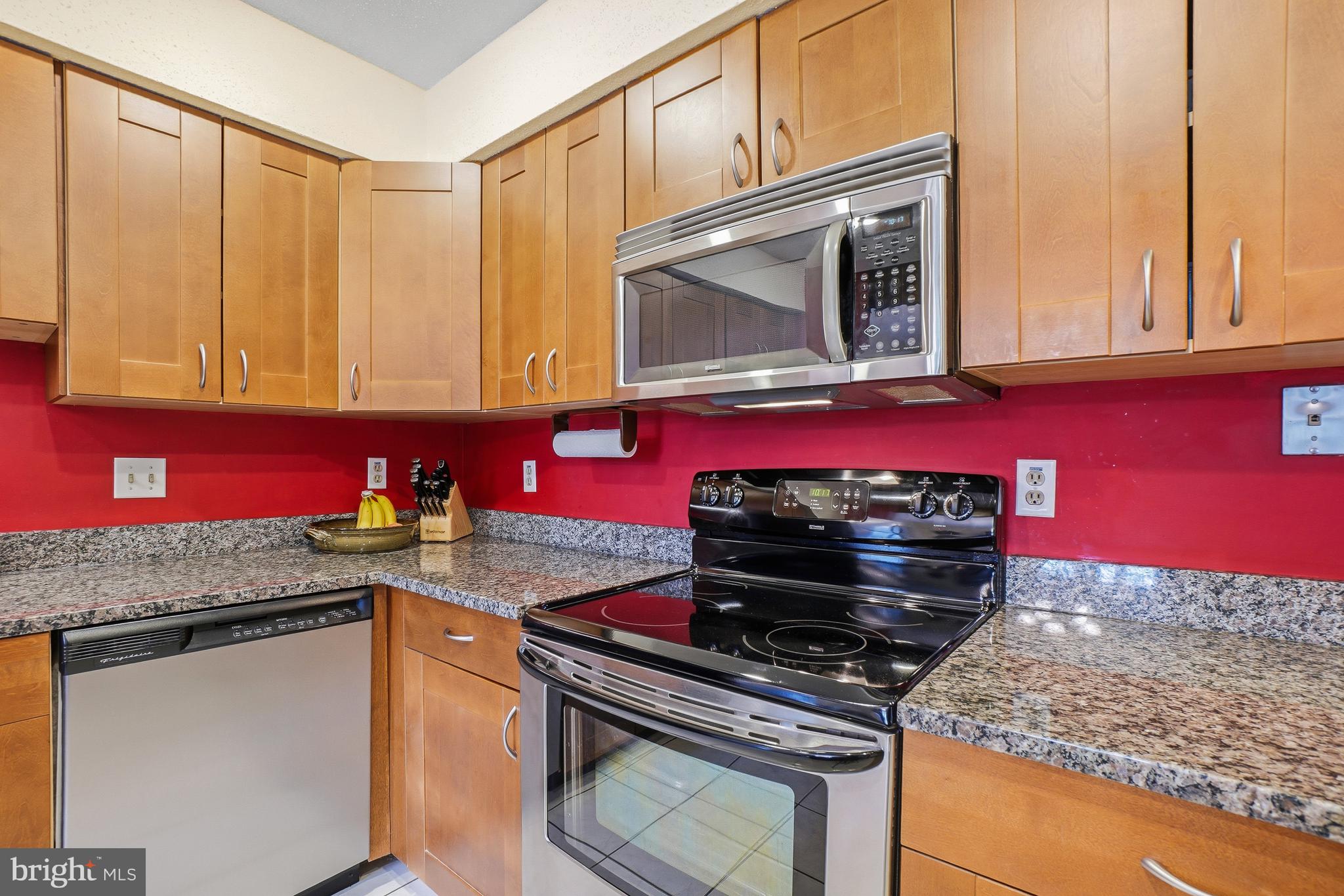 2315 Glade Bank Way Reston, VA 20191 - Photo 7 of 52 a kitchen with granite countertop a stove top oven microwave and cabinets