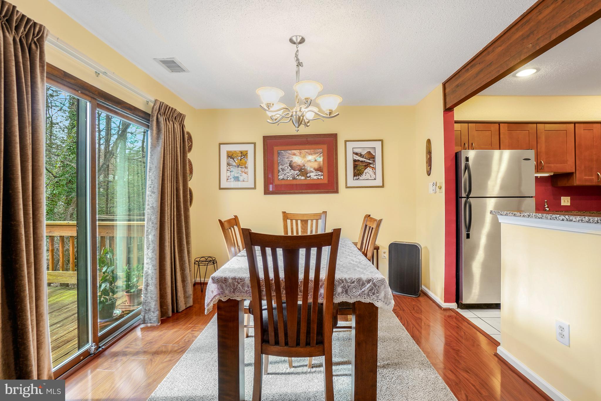2315 Glade Bank Way Reston, VA 20191 - Photo 10 of 52 a view of a dining room with furniture a chandelier and a large window