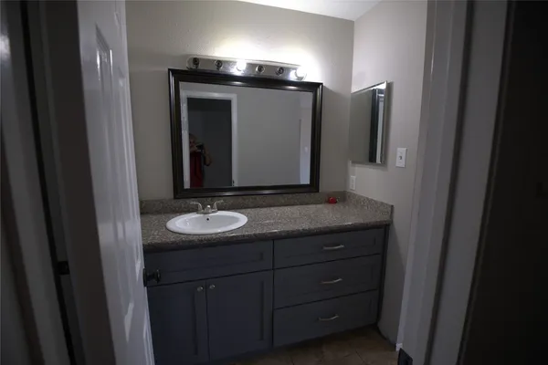 a bathroom with a granite countertop sink and a mirror
