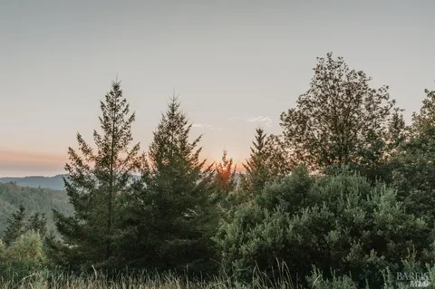 a bedroom with a bed and large windows