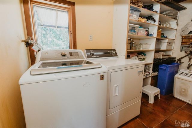 a living room with stainless steel appliances granite countertop furniture and a kitchen view