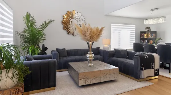 a living room with furniture a fireplace and a chandelier