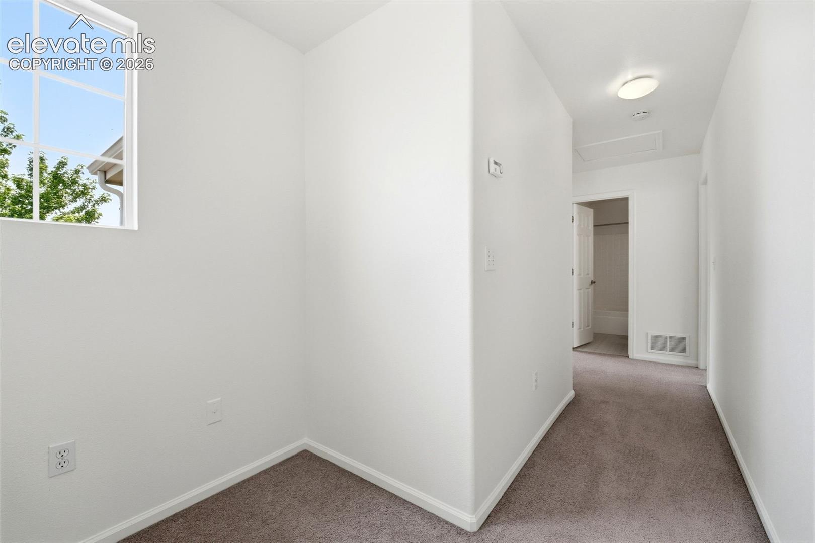 7904 Coffee Road Peyton, CO 80831 - Photo 18 of 48 Neutral-toned carpet flooring extends throughout this interior space with white baseboards
