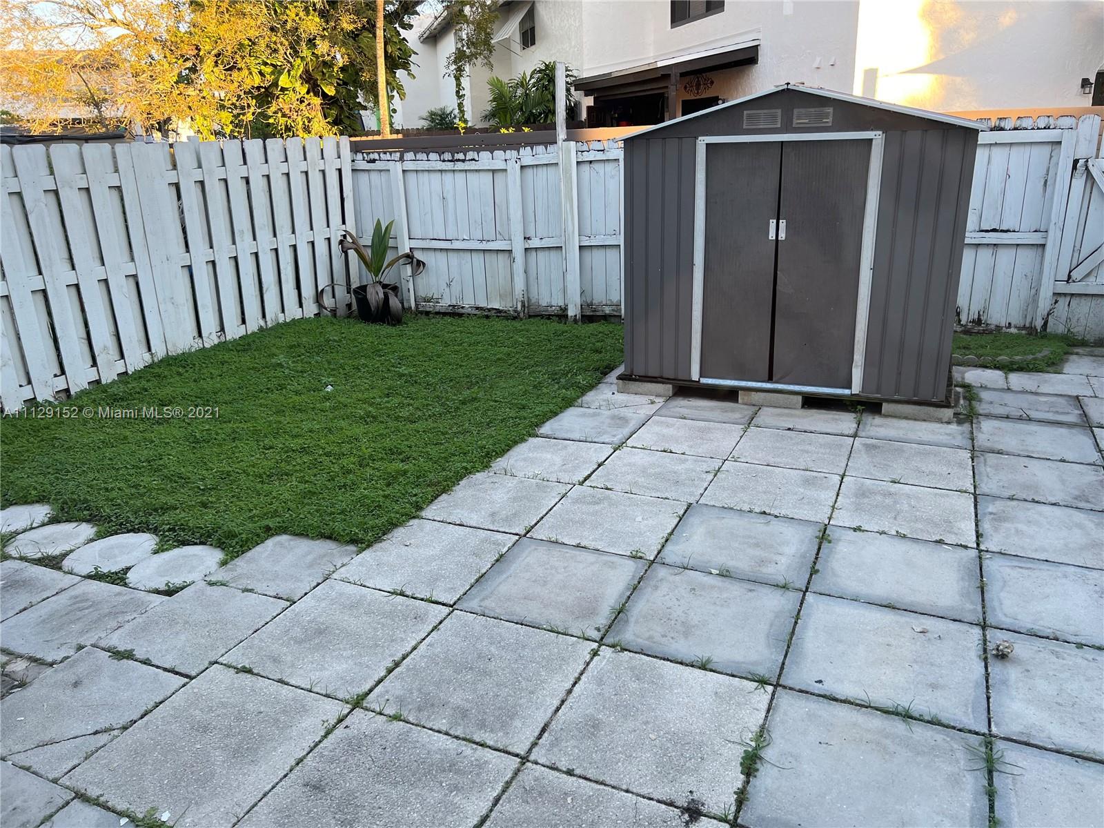 7009 Southwest 109th Place Miami, FL 33173 - Photo 3 of 7 a view of backyard with barbeque grill and wooden fence
