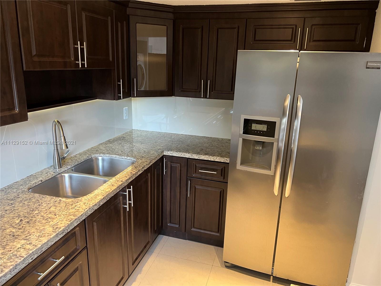 7009 Southwest 109th Place Miami, FL 33173 - Photo 6 of 7 a kitchen with a refrigerator and a sink