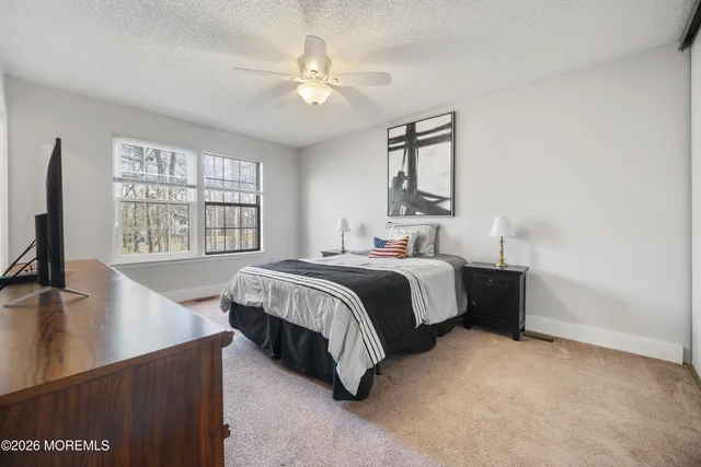 a bedroom with a bed window and a flat screen tv