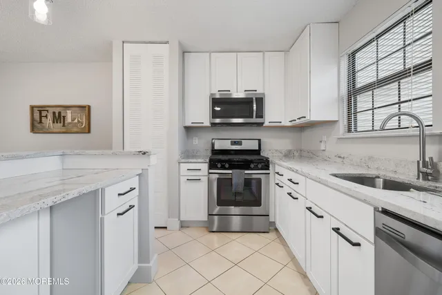a kitchen with granite countertop a sink and steel appliances