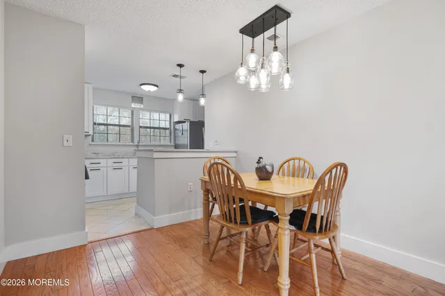 a view of a dining room with furniture a chandelier and wooden floor