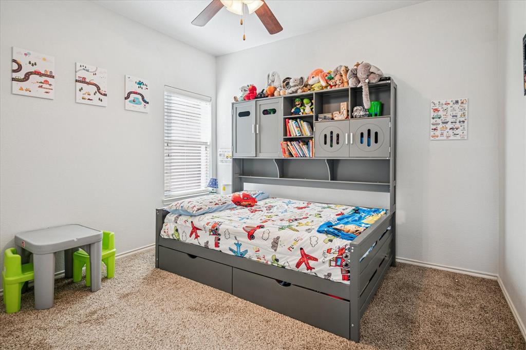 111 Freedom Trail Forney, TX 75126 - Photo 11 of 16 a bedroom with a bed and a chandelier