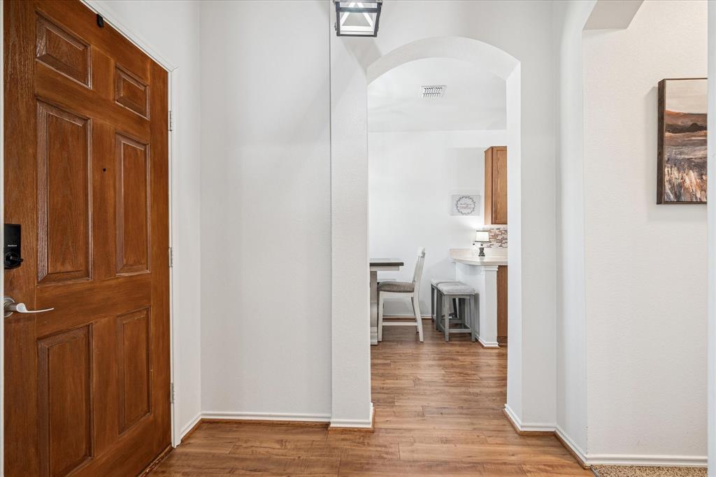 111 Freedom Trail Forney, TX 75126 - Photo 2 of 16 a view of a hallway with wooden floor and a living room