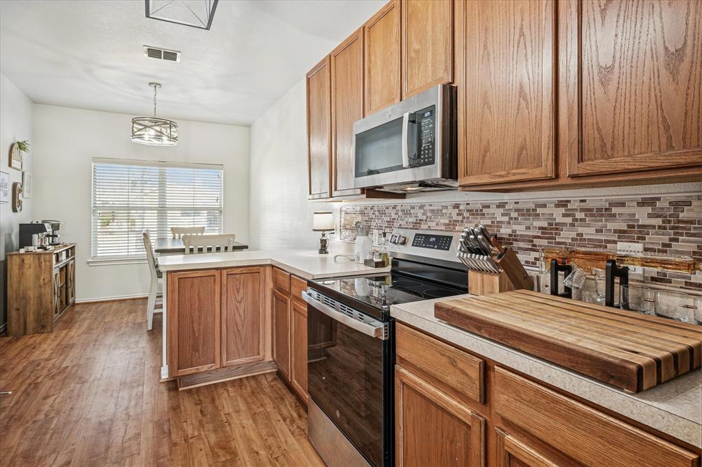 111 Freedom Trail Forney, TX 75126 - Photo 6 of 16 a kitchen with stainless steel appliances granite countertop a stove a sink and a microwave