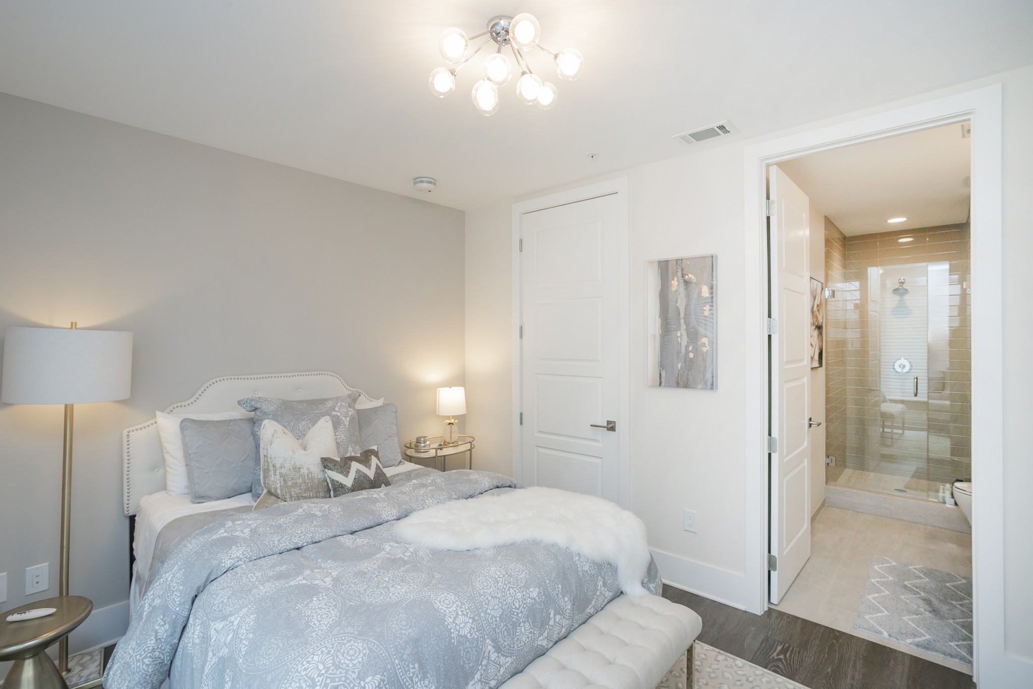 20 Rutledge Street, Unit 104 Nashville, TN 37210 - Photo 16 of 35 a bedroom with a bed and a chandelier