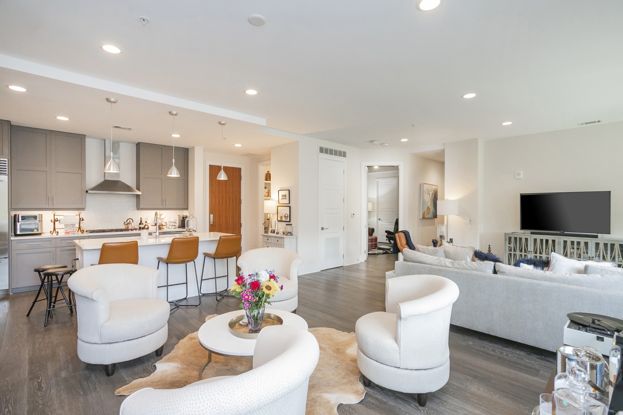 20 Rutledge Street, Unit 104 Nashville, TN 37210 - Photo 7 of 35 a living room with furniture kitchen view and a flat screen tv