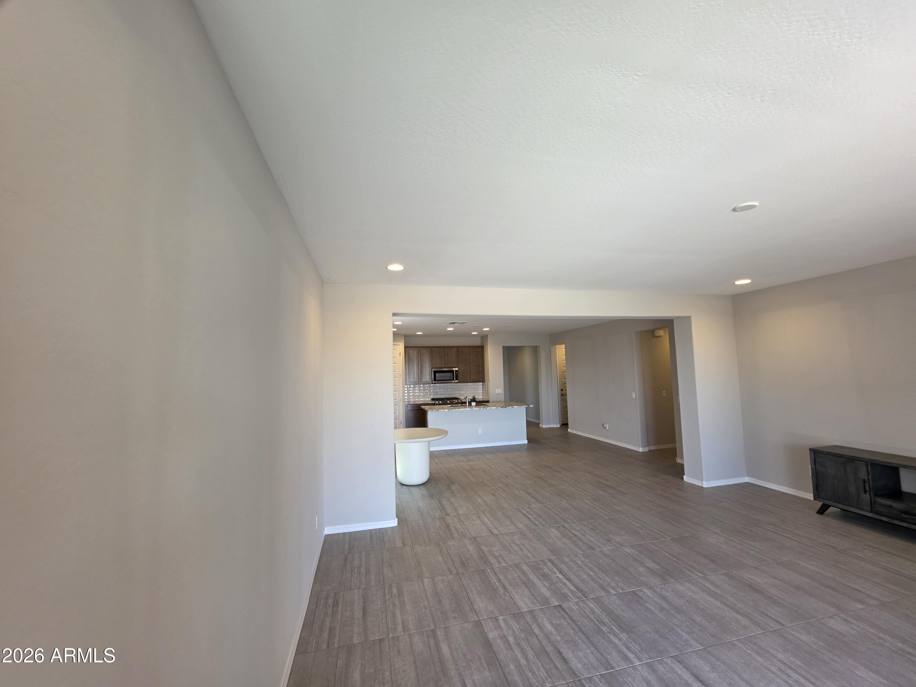 7128 West Coles Road Laveen, AZ 85339 - Photo 11 of 38 a view of a kitchen and an empty room with wooden floor