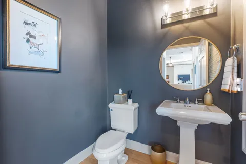 a bathroom with a toilet a sink and a mirror