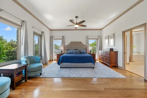 a bedroom with a large bed a chandelier and windows