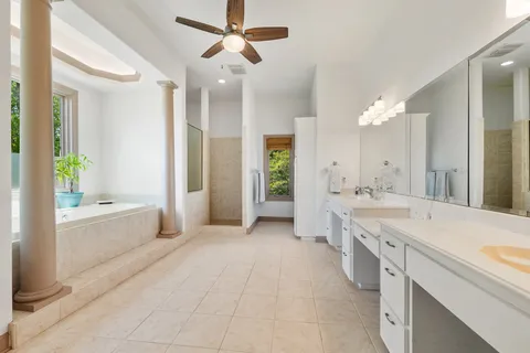a large spacious bathroom with a granite countertop tub sink shower and mirror