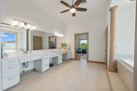 a large bathroom with a double vanity sink a large mirror and a bathtub