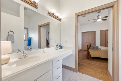 a en suite bathroom with a double vanity sink a mirror and bathtub
