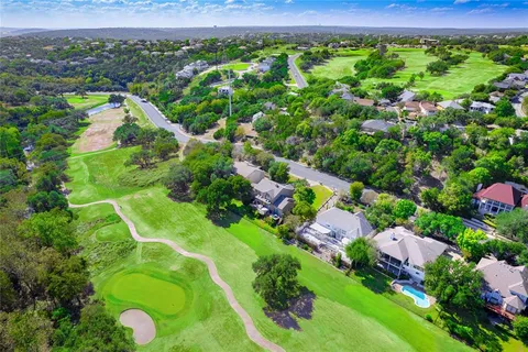 an aerial view of residential houses with outdoor space and trees