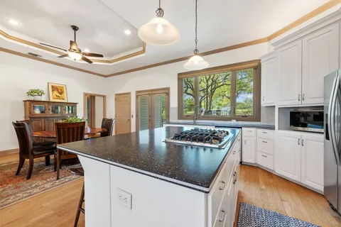 a kitchen with a stove a sink a microwave and dining table
