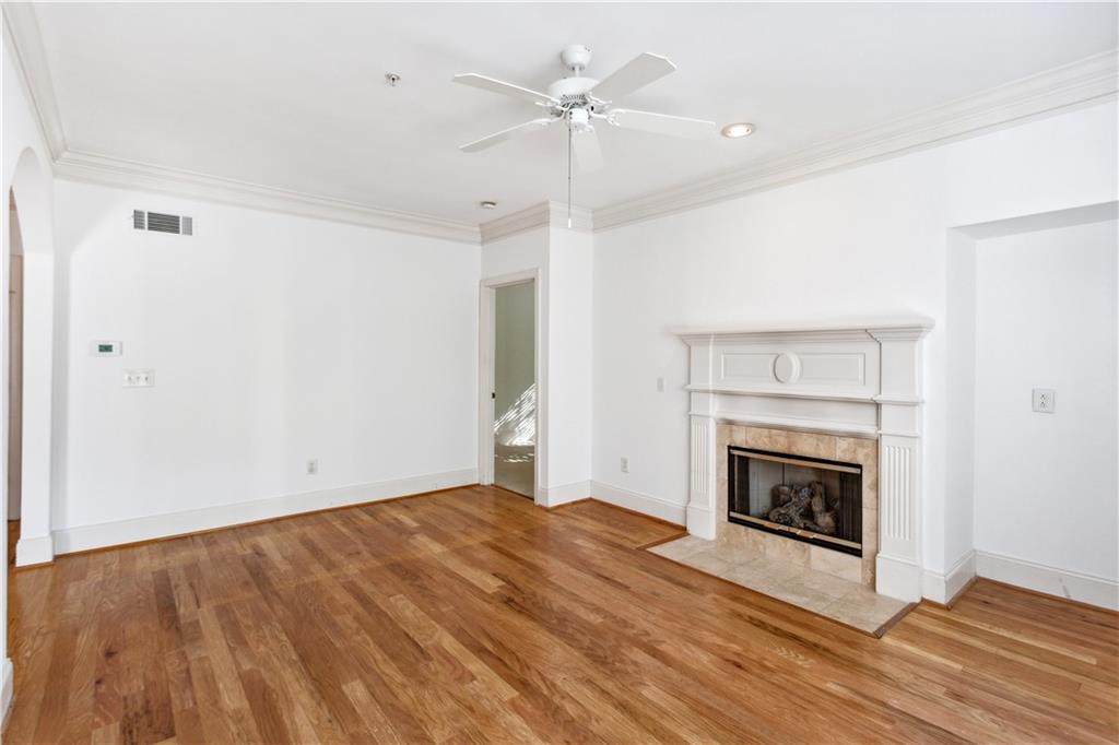 4100 Paces Walk Southeast, Unit 3205 Atlanta, GA 30339 - Photo 9 of 17 an empty room with a fireplace and fan